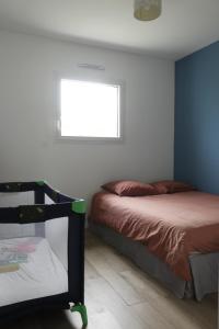 1 dormitorio con 2 camas y ventana en maison calme, en Baden