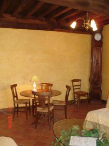 una sala da pranzo con tavoli, sedie e orologio di Au temps d'Autrefois a Nolay