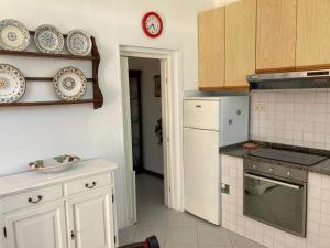 a kitchen with white appliances and a clock on the wall at Casa Rina in Livorno