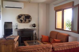 sala de estar con sofá y chimenea en 'El Mirador de Sotillo', un Oasis de Confort con Piscina y Jacuzzis, en Sotillo de la Adrada
