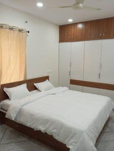 海得拉巴的住宿－Ahasa Glen，一间卧室配有一张带白色床单的大床