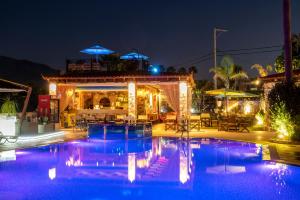 a swimming pool in front of a restaurant at night at Socrates Studios in Tigaki