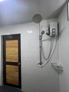 a shower in a bathroom with a wooden door at Rasdu View Inn in Rasdhoo