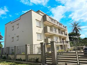 a white building with a fence in front of it at Akhard Haus in Buea