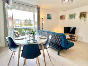 ジョネ・クランにあるLe Nirvana ~ Jolie t2 avec Balcon / 2 min du parcのテーブルと椅子とテレビのあるダイニングルーム