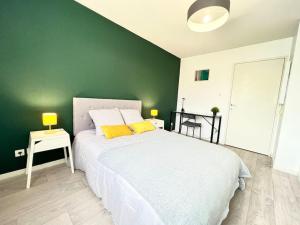 ジョネ・クランにあるLe Nirvana ~ Jolie t2 avec Balcon / 2 min du parcの緑の壁のベッドルーム1室(白いベッド1台付)
