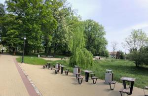 a row of benches on a sidewalk in a park at Na Kamiennej in Kołobrzeg