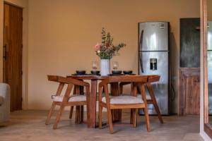 een keuken met een tafel met stoelen en een koelkast bij Xamira Tulum Studios in Tulum