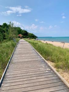 a wooden path leading to a beach with people on it at Beautiful Luxury Suite A of Shorewood Home in Shorewood