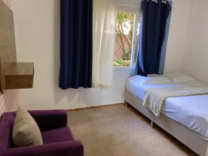 um quarto com uma cama, uma janela e um sofá em Pousada Paisagem em Jaraguá do Sul