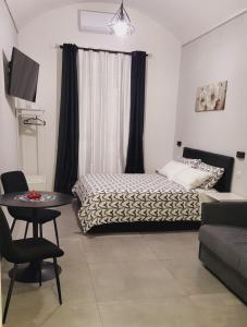 1 dormitorio con cama, mesa y sofá en Giglio Rosso, en Bari
