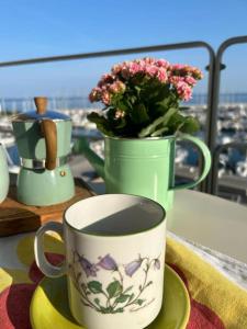 une tasse de café assise sur un plateau avec une plante dans l'établissement Maya's house, à Punta Ala