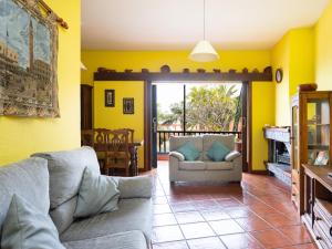 sala de estar con paredes amarillas y sofá en Live Garachico Villa Daute con terraza y piscina en Las Cruces