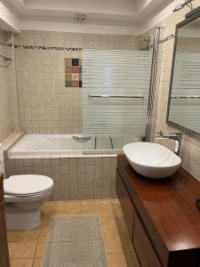 e bagno con vasca, servizi igienici e lavandino. di Peaceful Escape a Kavala