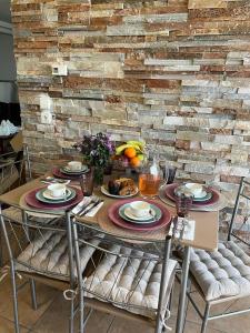uma mesa com pratos de comida em frente a uma parede de tijolos em Peaceful Escape em Kavala
