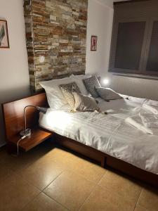 Ce lit se trouve dans une chambre dotée d'un mur en briques. dans l'établissement Peaceful Escape, à Kavala