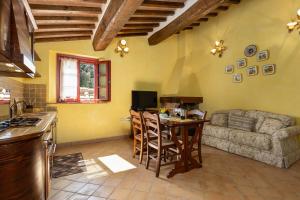 een keuken en een woonkamer met een bank en een tafel bij Borgo Mommialla Casa Alessandra in Gambassi Terme