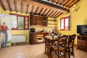 een keuken met een tafel en stoelen in een kamer bij Borgo Mommialla Casa Alessandra in Gambassi Terme