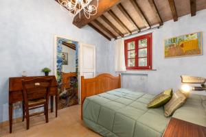 a bedroom with a bed and a desk and a window at Borgo Mommialla Casa Alessandra in Gambassi Terme