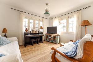 a living room with a television and a piano at Maria La Franca in La Franca