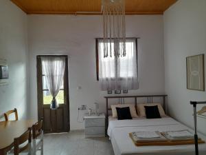 a bedroom with two beds and a table and a window at FG HOME RENTAL b in Mirodháton