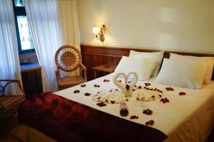 a hotel room with a bed with roses on it at Campos Hotel do Sol in Campos do Jordão