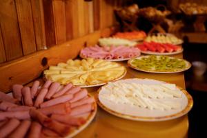 uma mesa com muitos pratos de comida em Campos Hotel do Sol em Campos do Jordão