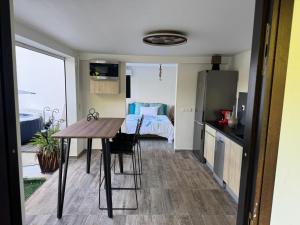 a kitchen with a table and a bedroom with a bed at Le Clos de Bourgueil in Sainte-Anne +2 photos