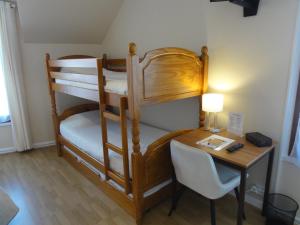 a room with two bunk beds and a desk at Hotel des Voyageurs in Payzac