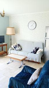 a living room with a couch and a clock on the wall at Gîte paisible 