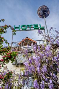 a sign with purple flowers in front of a hotel at Residenz Hotel Leipzig in Leipzig