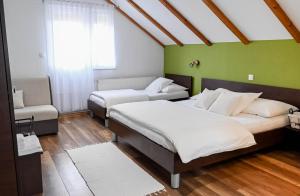 a room with two beds and a chair in it at Guesthouse Rubcic in Rakovica