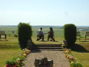 two people sitting on a bench in a park at Saltcote Place in Rye