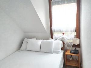 a bed with white pillows in a room with a window at Maison agréable à Le Crotoy, 57 m² avec vélos inclus in Le Crotoy