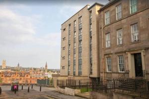 a large brick building with a city in the background at Cosy 1 Bed in City Centre Location in Glasgow