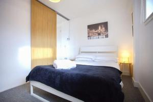 a bedroom with a large bed with a blue blanket at Cosy 1 Bed in City Centre Location in Glasgow