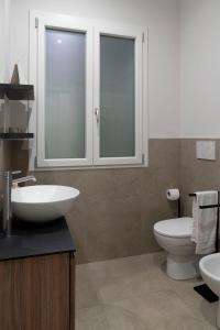 a bathroom with a white sink and a toilet at Le case di vada/ appartamento le Dune in Vada