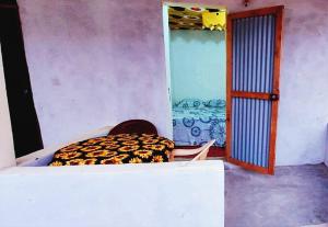 a room with a bed and a room with a door at Petit Hollande guest rooms in Abémé