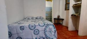 sypialnia z łóżkiem z niebiesko-białym kocem w obiekcie Petit Hollande guest rooms w mieście Abémé