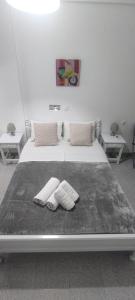 a bed with two towels on it with two tables at Garden Rooms in Matala