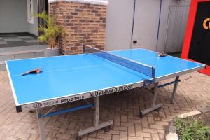 una mesa de ping pong azul sentada en un suelo de ladrillo en Rocket Room Hotel & Suites Limited, en Port Harcourt