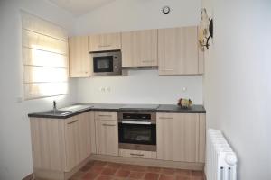 a kitchen with wooden cabinets and a sink and a microwave at Domaine la Garenne in Saint-Marc-Jaumegarde