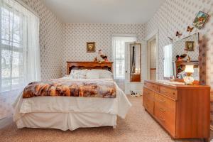 a bedroom with a bed and a dresser and a dresser at Quiet Farmhouse Retreat with Fire Pit - Pets Welcome! in Milltown