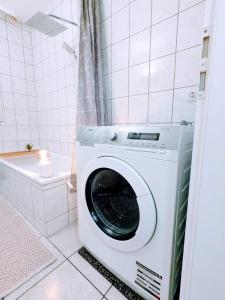 a washing machine in a bathroom with a tub at Wohnung nahe Messe und Zentrum in Nuremberg