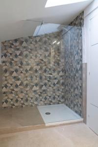 La salle de bains est pourvue d'une douche avec une porte en verre. dans l'établissement Le case di vada - Il Faro, à Vada