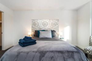 Un dormitorio con una cama grande con una manta azul. en Vibrant Modern Oasis - Long Stays - Netflix - Wi-Fi en Edmonton