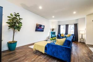 a living room with a blue couch and a potted tree at Vibrant Modern Oasis - Long Stays - Netflix - Wi-Fi in Edmonton