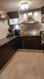 a kitchen with wooden floors and a kitchen with a stove at Room close to city centre and beach in Oslo
