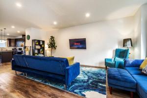 a living room with two blue couches and a kitchen at Vibrant Modern Oasis - Long Stays - Netflix - Wi-Fi in Edmonton