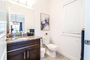 baño con aseo y lavabo y ventana en Vibrant Modern Oasis - Long Stays - Netflix - Wi-Fi en Edmonton